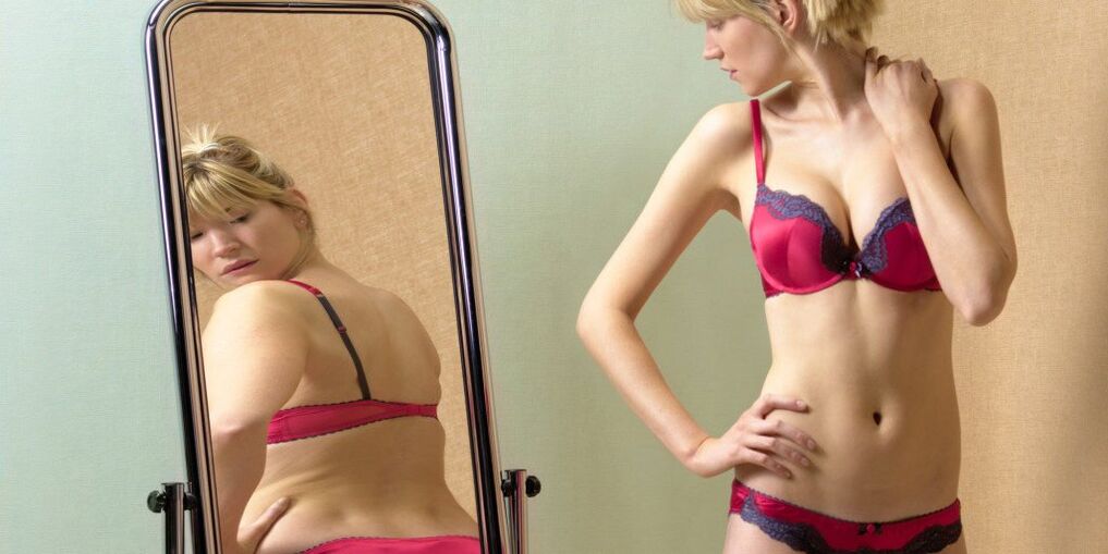 La ragazza considera il suo riflesso nello specchio